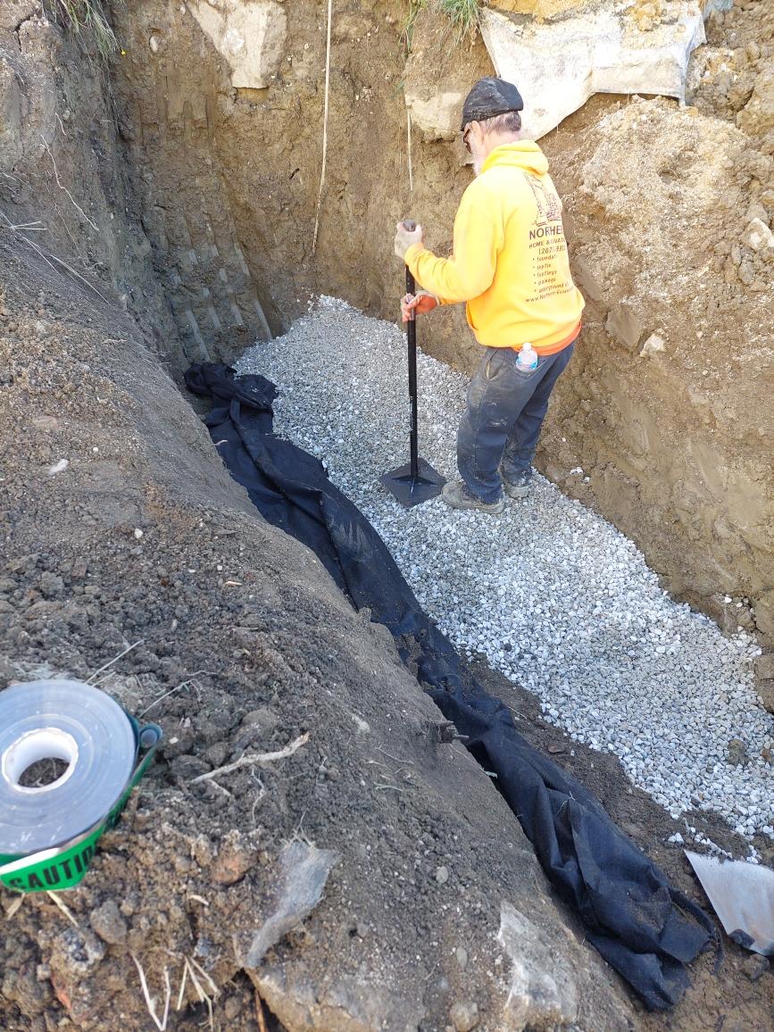Worker Leveling Gravel on the Excavated Area