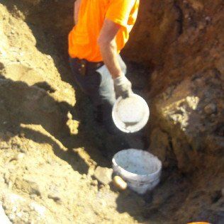 Worker Collecting Soil Using a Bucket
