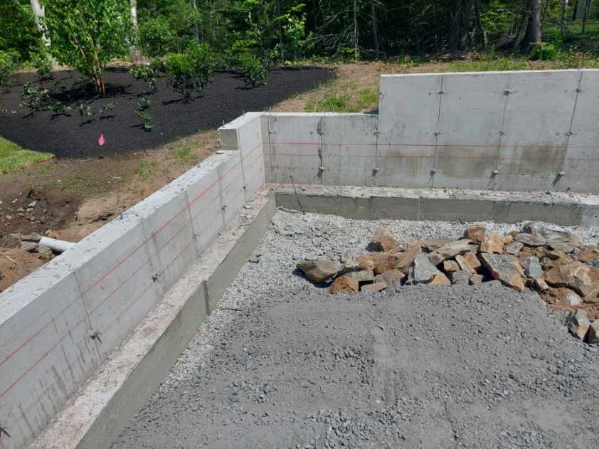 A concrete wall is being built in a backyard.