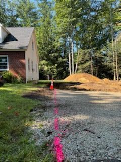 There is a pink line on the ground in front of a house.
