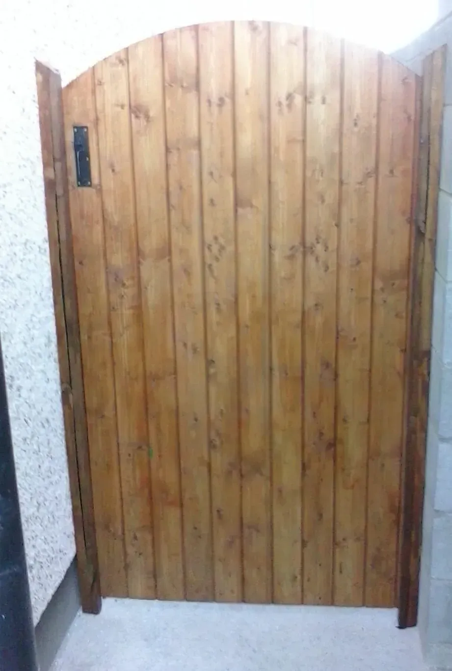 A wooden gate is sitting in a room next to a wall.