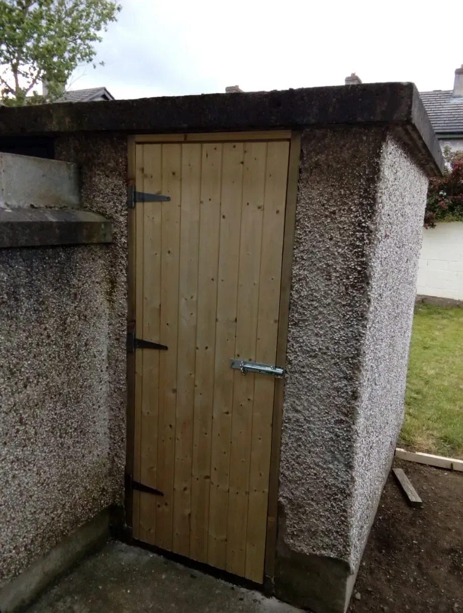 A small shed with a wooden door on it