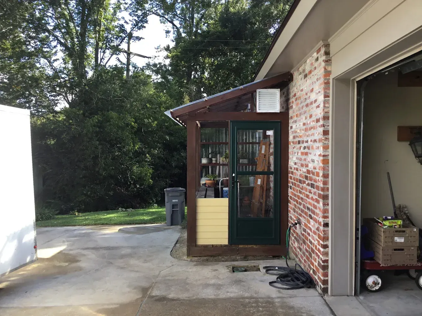 A garage with a green door and a brick wall