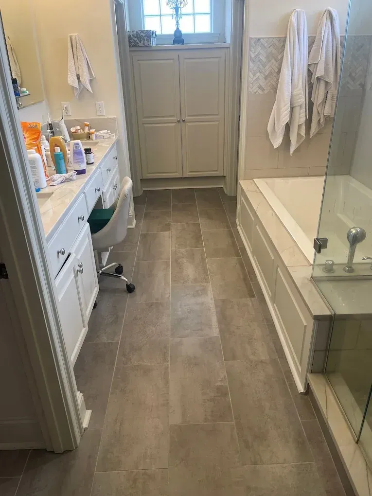 A bathroom with a tub , sink , and mirror.
