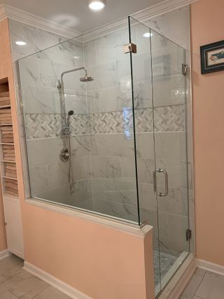 Glass shower enclosure with tiled walls and a peach-colored exterior.