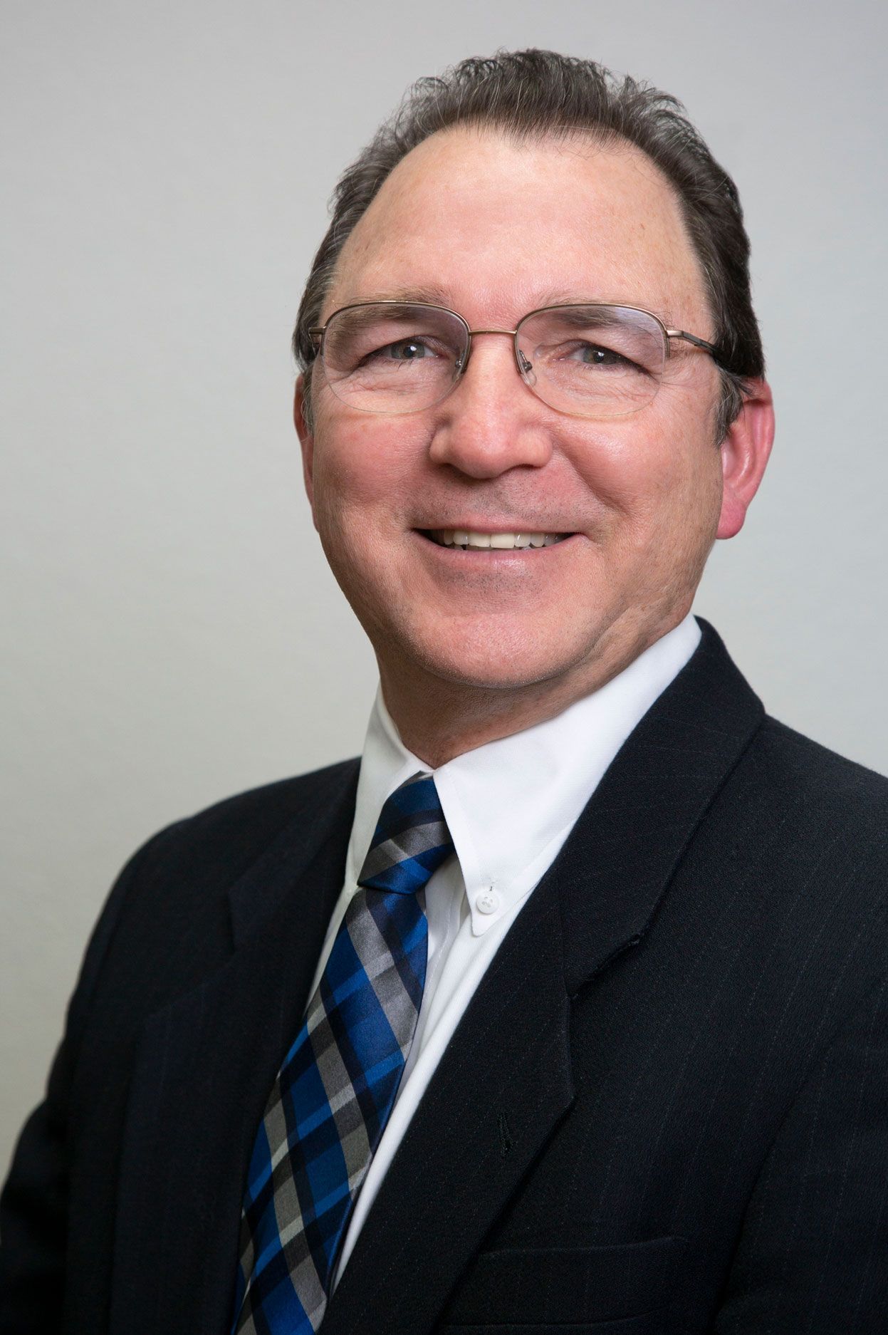 A man in a suit and tie is smiling for the camera.