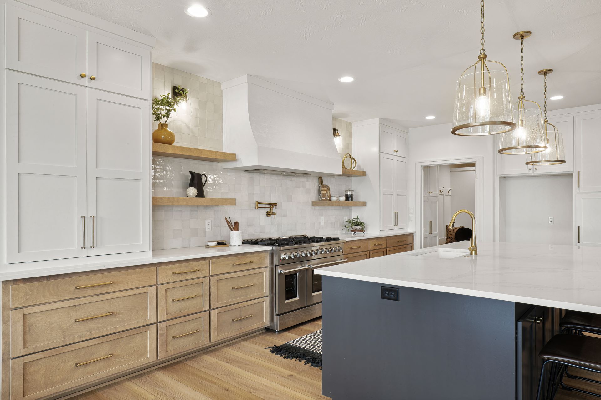 Modern kitchen with white and wood cabinets, stainless steel appliances, and a large island.