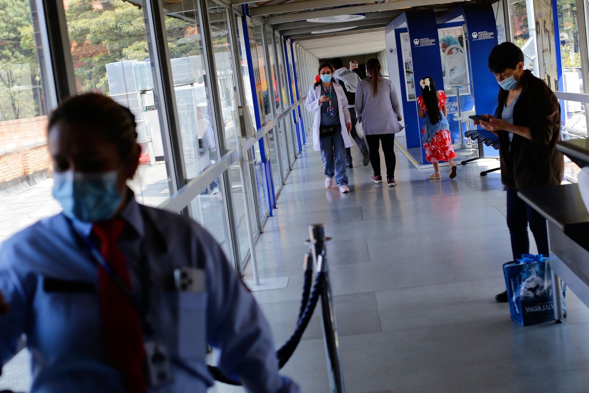 Pacientes y personal caminan por uno de los corredores del Hospital San Ignacio, en Bogotá, el 25 de enero de 2024.