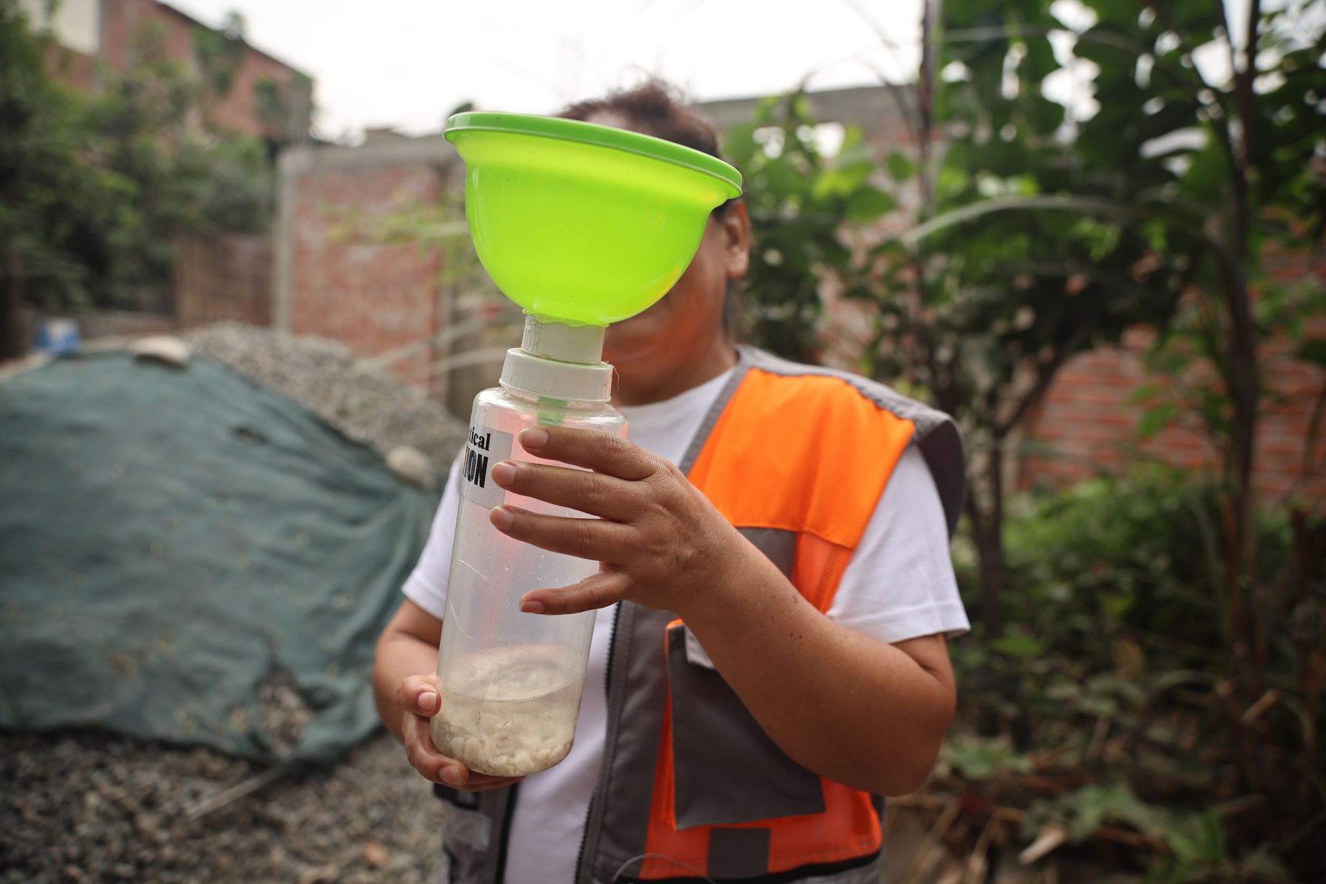 Raquel Izarra sostiene un vaso de aluviones con un pluviómetro.