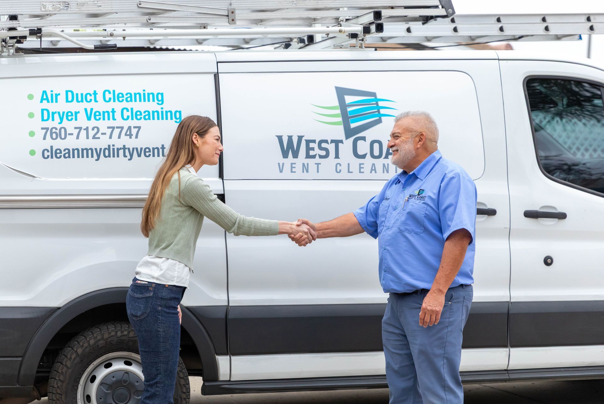 A person shakes hands with a service professional in front of a white van branded with 