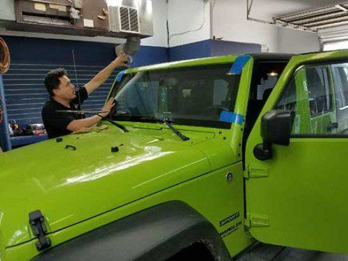 Windshield Replacement — Man repairing car windshield in Colorado Spring, CO