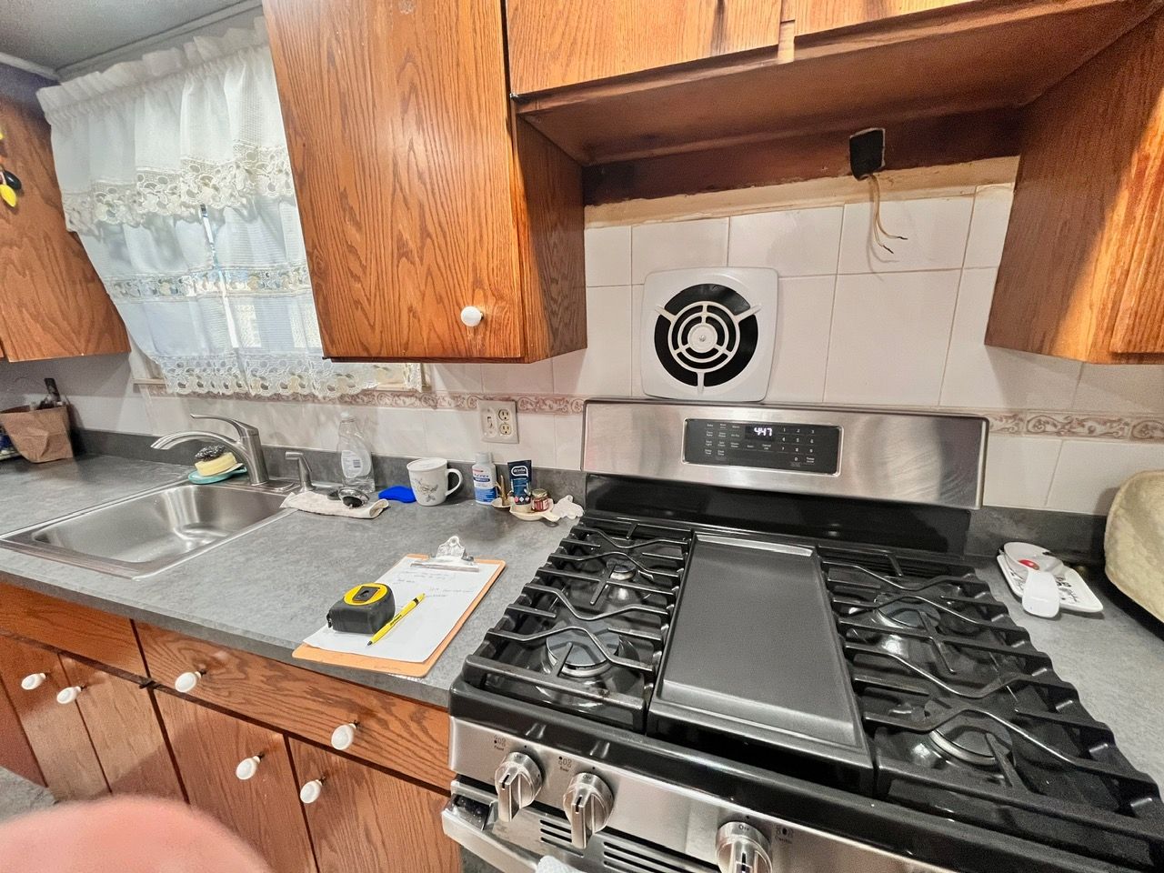 A kitchen with a stove top oven and a sink.