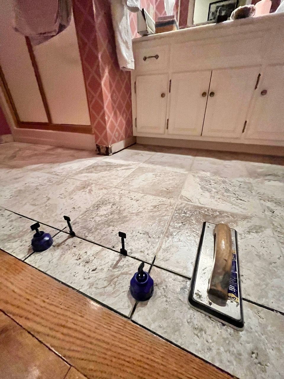 A bathroom with a tile floor and a mirror.