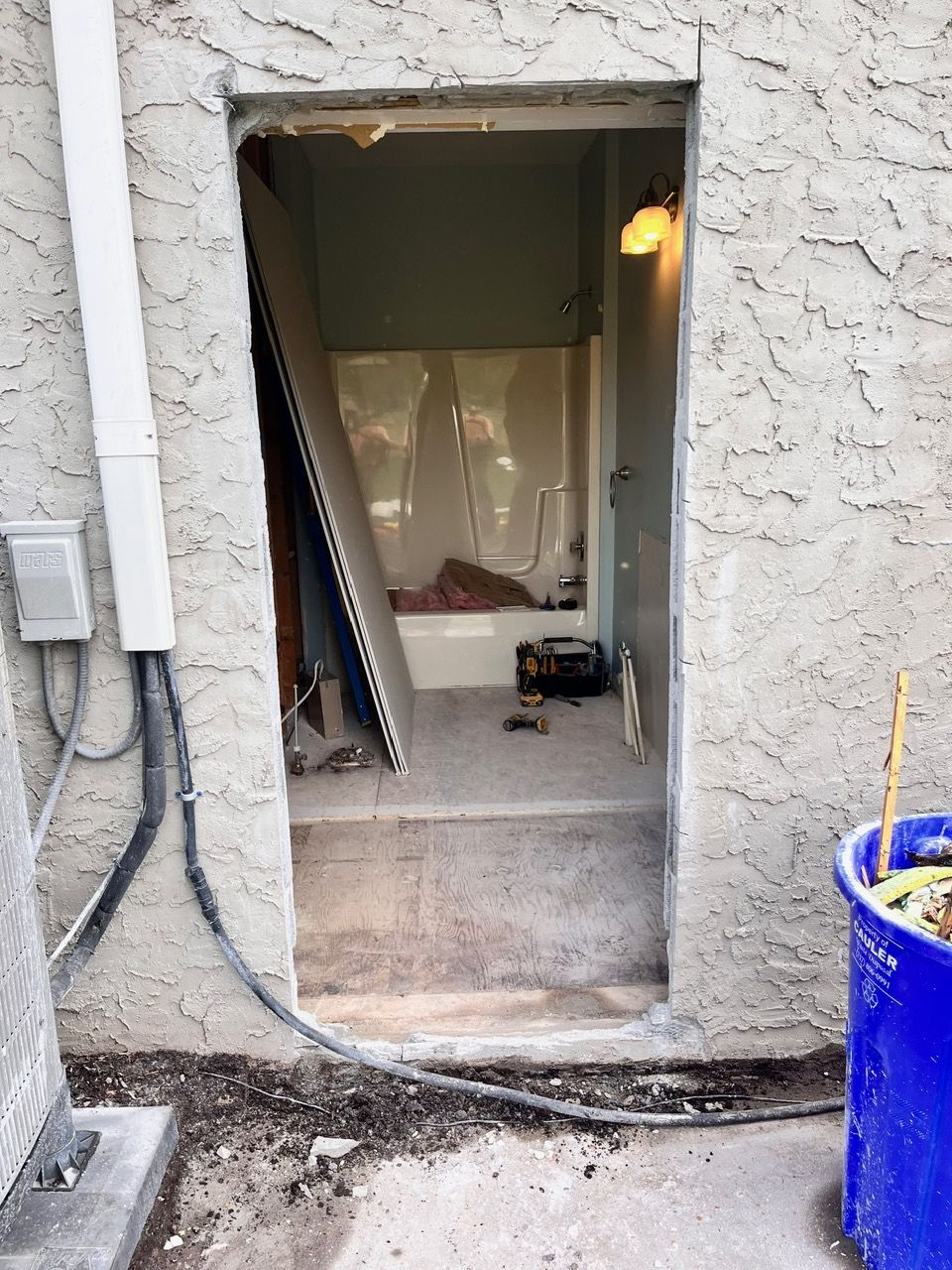 A door is open to a bathroom with a bathtub in it.
