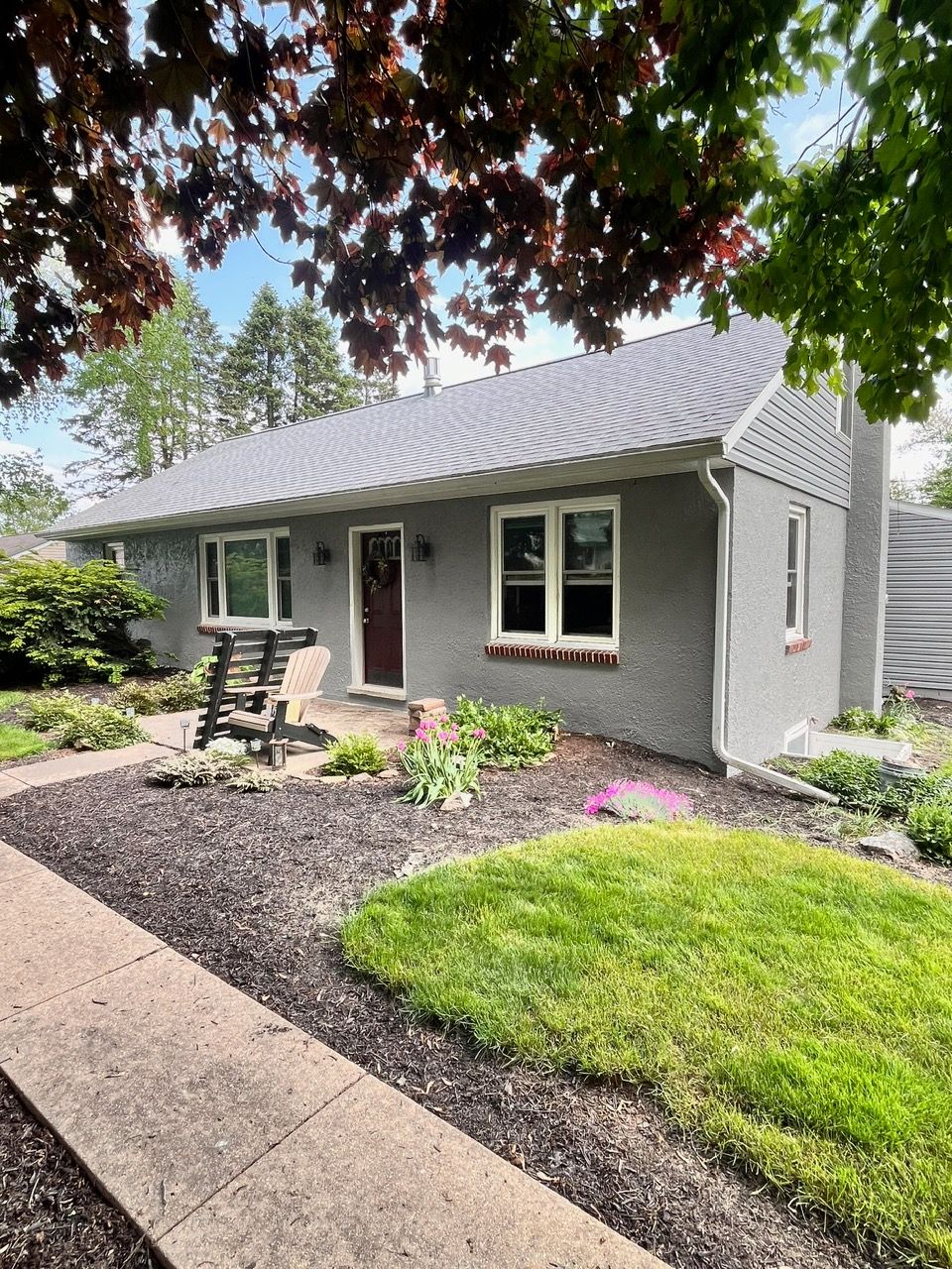 A gray house with a metal roof is for sale.