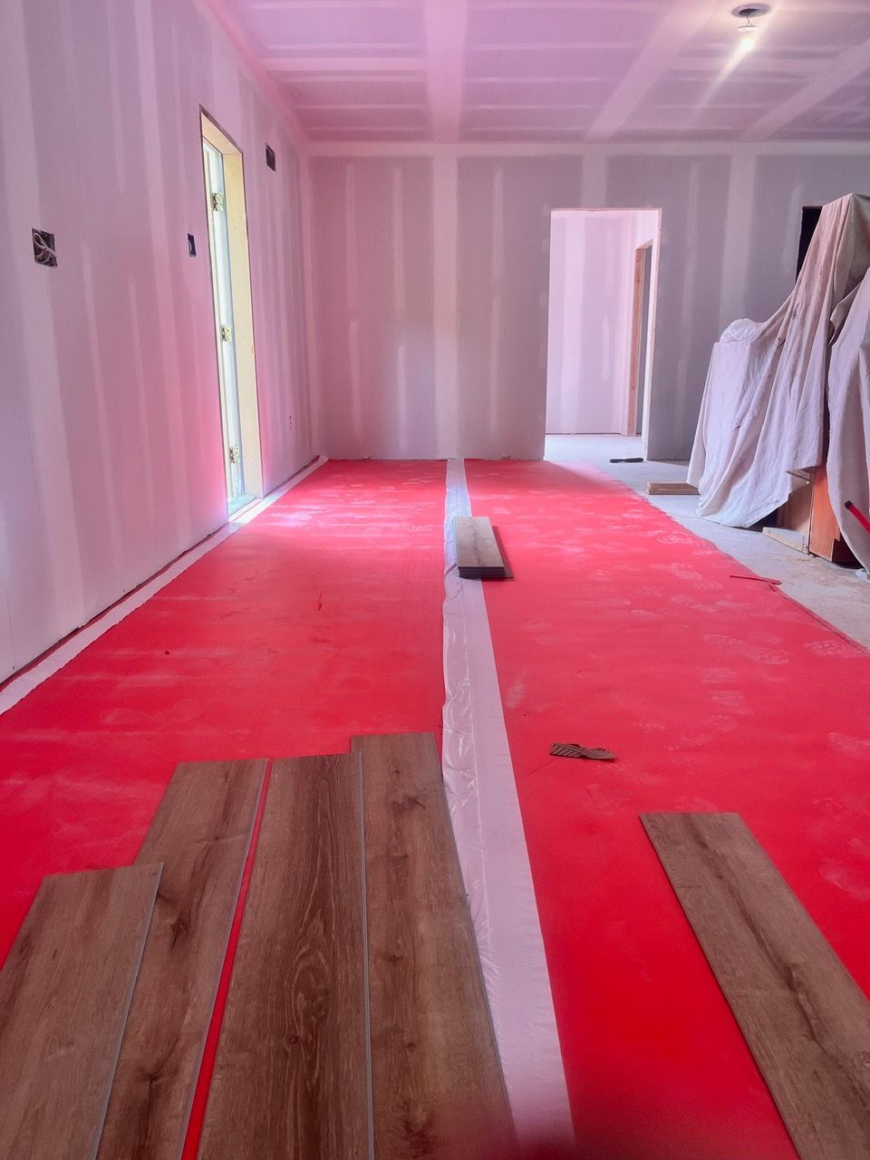 A room with wooden floors and a red mat on the floor.