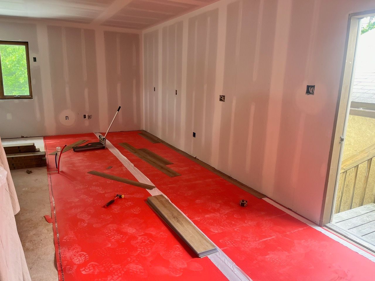 A room with a red mat on the floor and a window.