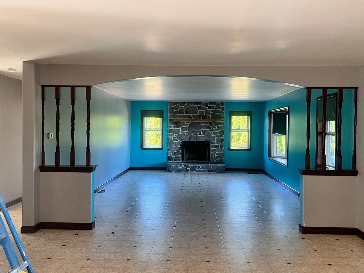 A living room with blue walls and a fireplace.