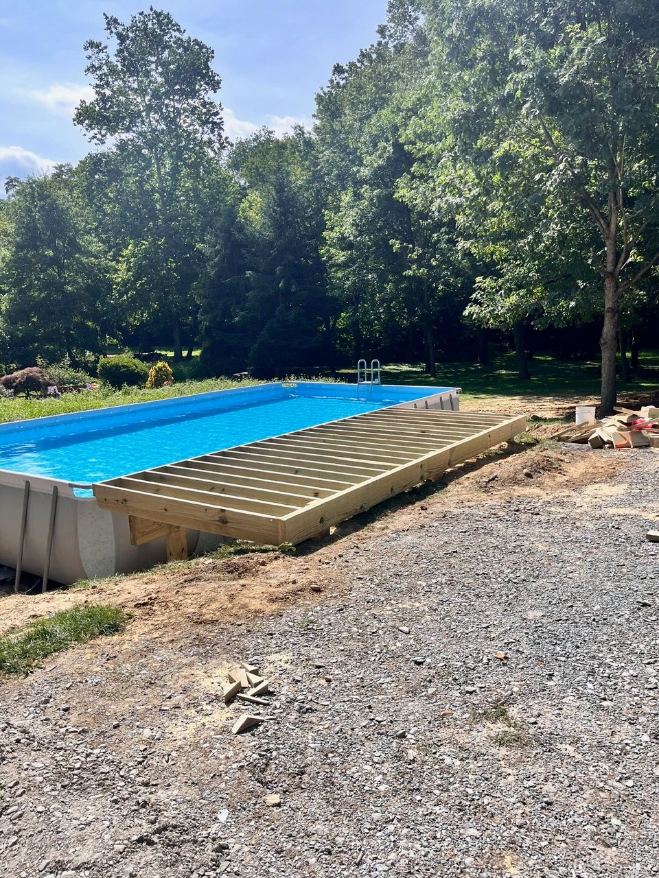 A swimming pool with a wooden deck underneath it
