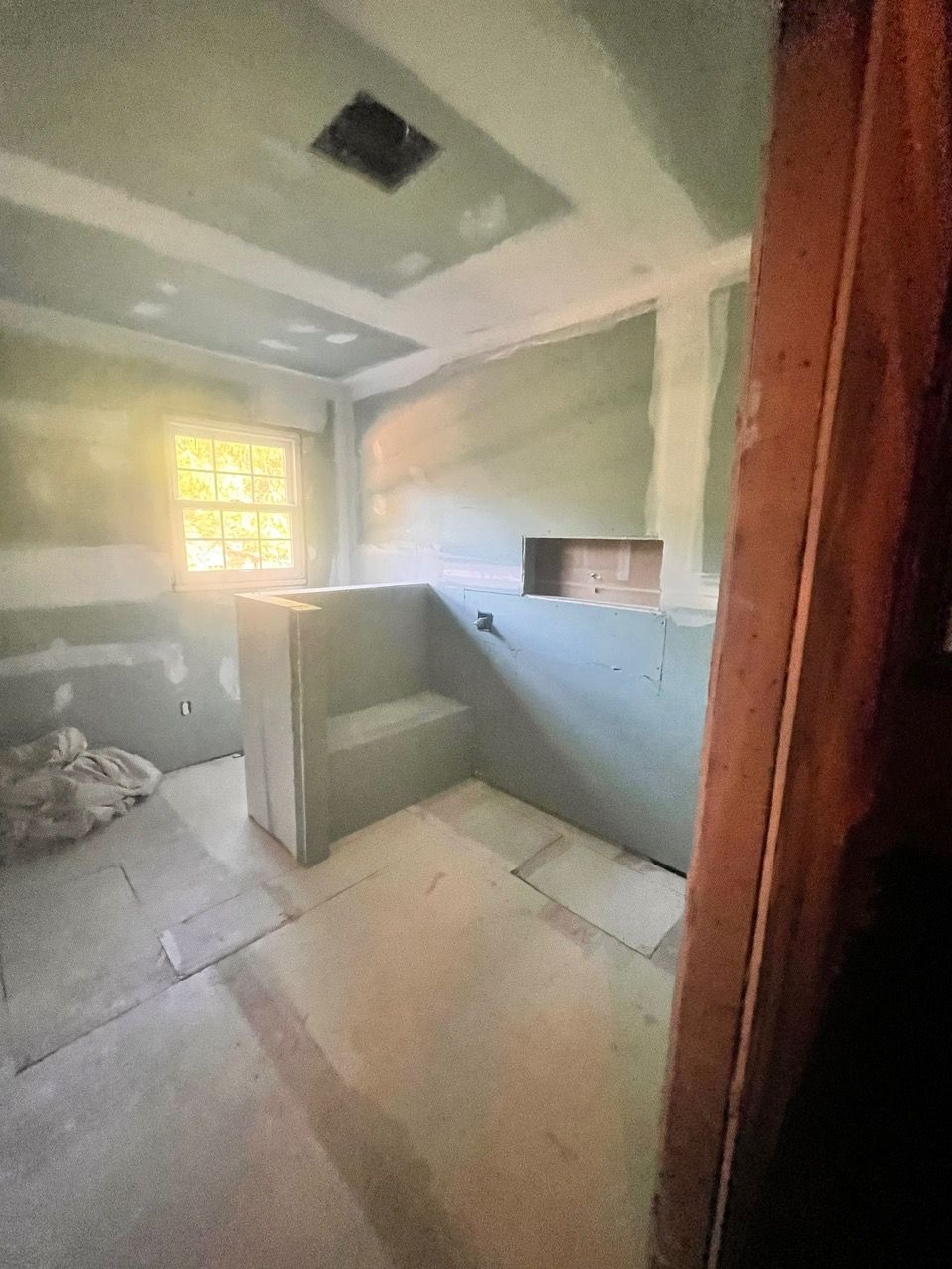 A bathroom under construction with a window in the ceiling.