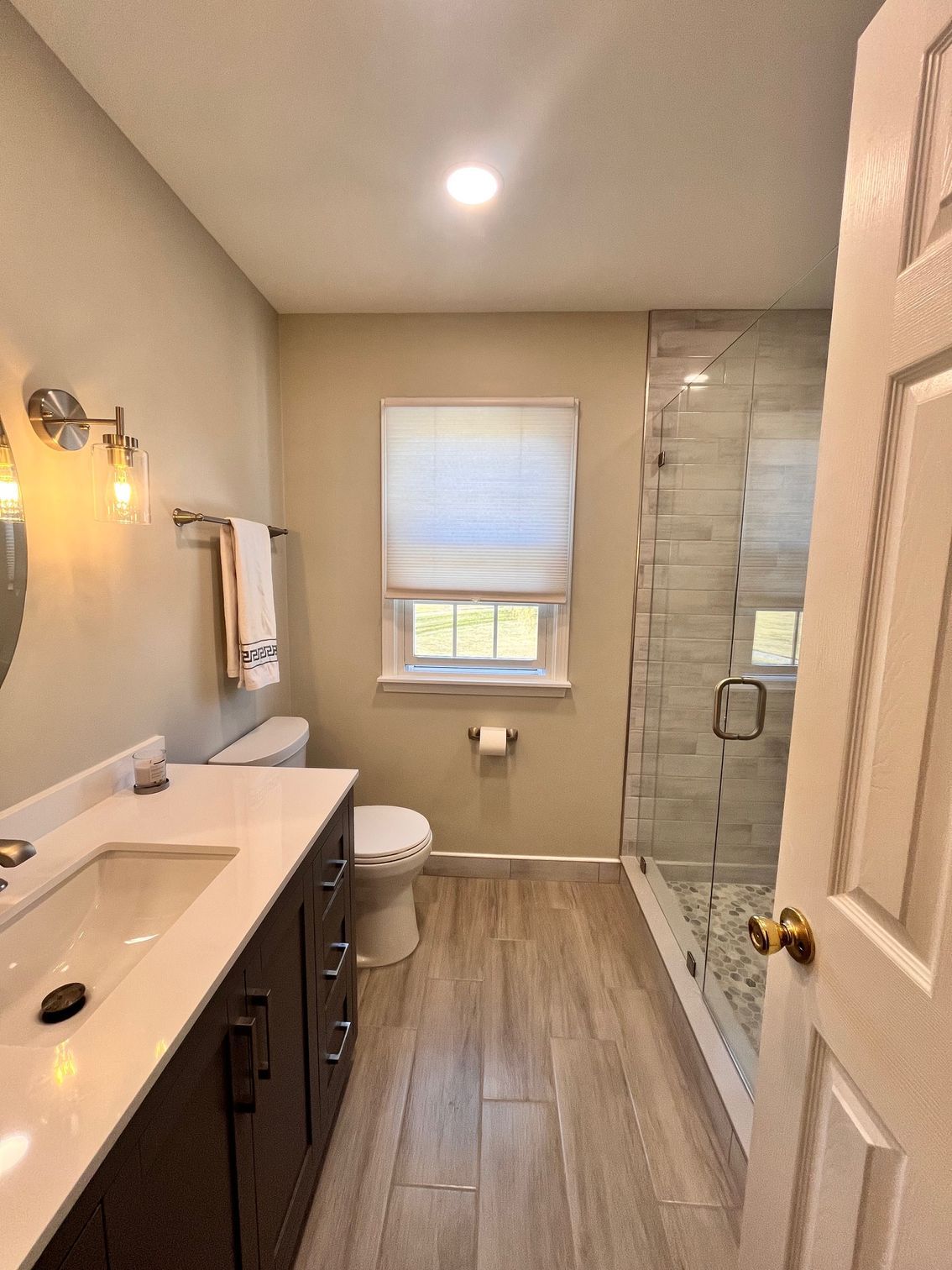 A bathroom with a toilet , shower , and tile floor.