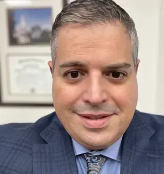 A man in a suit and tie is smiling for the camera.