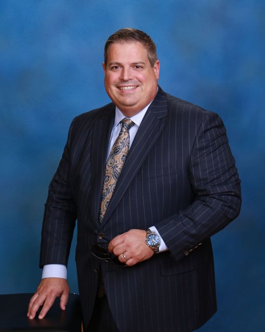 A man in a suit and tie is smiling for the camera.