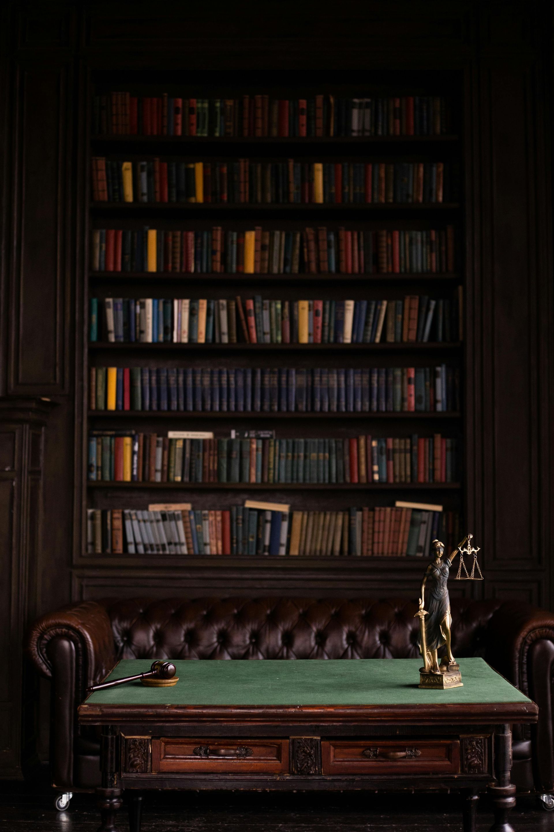There is a statue of justice on the table in the library.