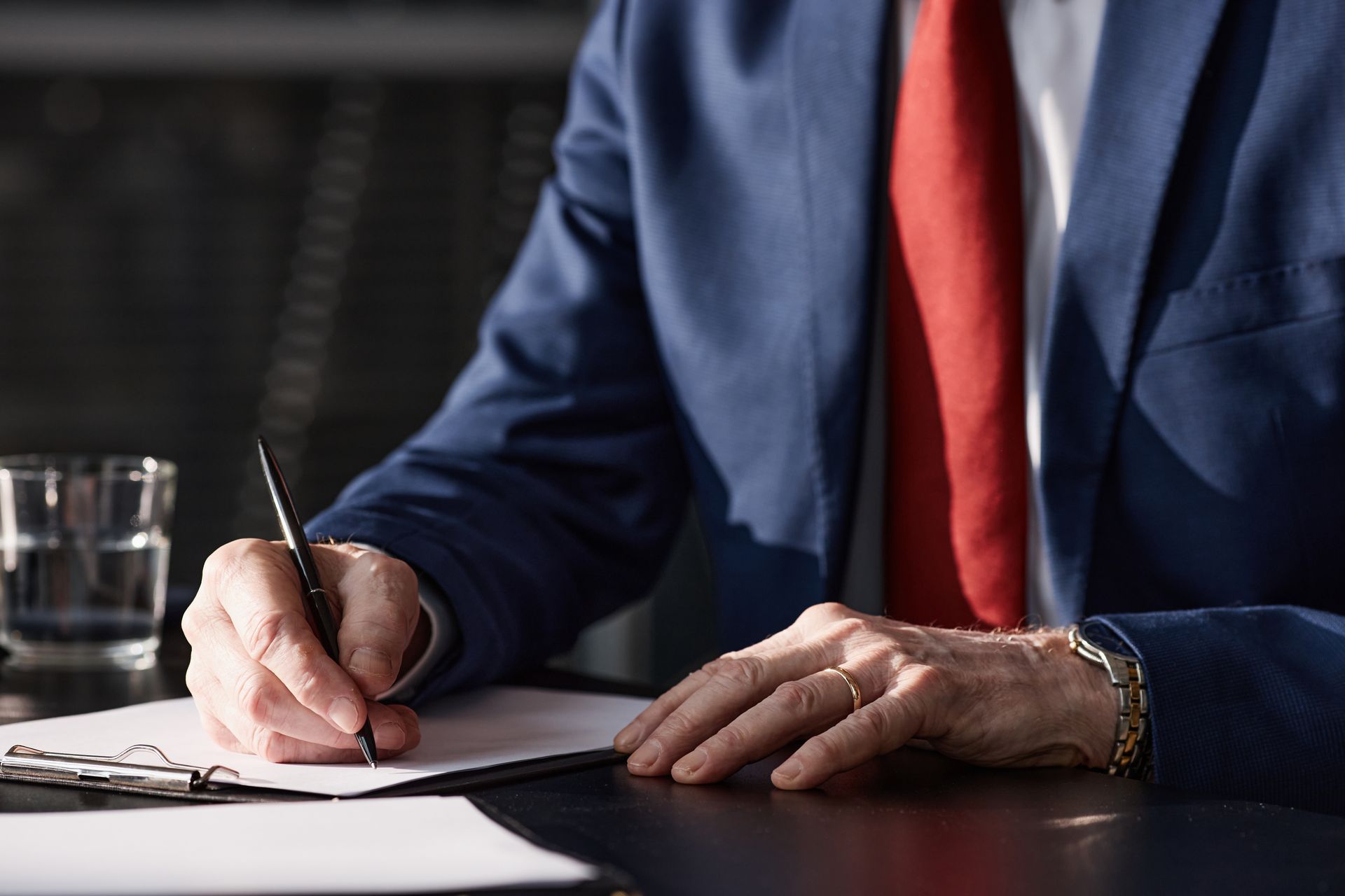 Close-up of a professional DWI lawyer signing paperwork to protect a client's legal rights.