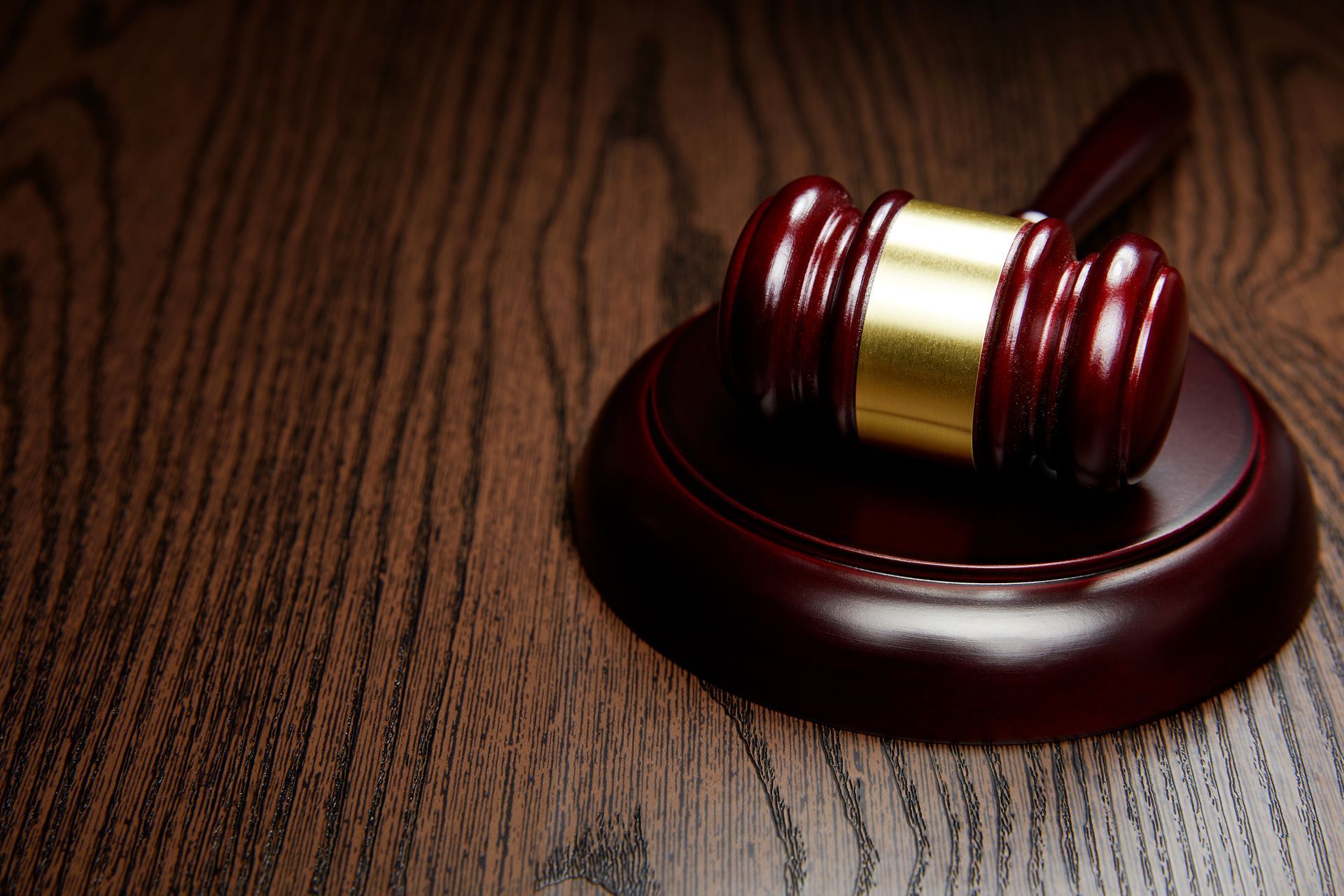 A wooden gavel on top of a wooden table.