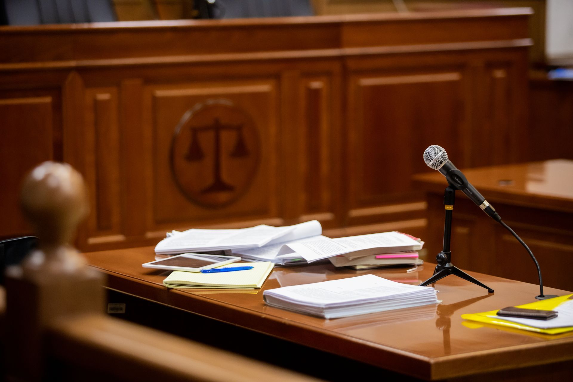 Microphone and paperwork on a courtroom desk. Microphone and paperwork on a courtroom desk.
