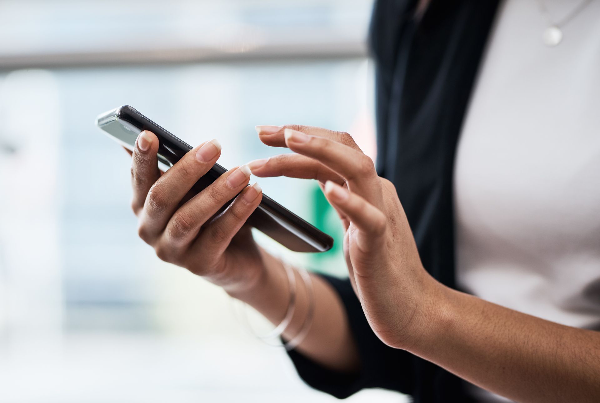 A woman is holding a cell phone in her hands — Eau Claire, WI — Cohen Law Offices