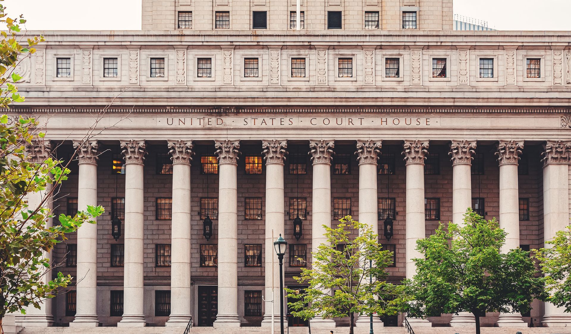 A large building with columns and trees in front of it.