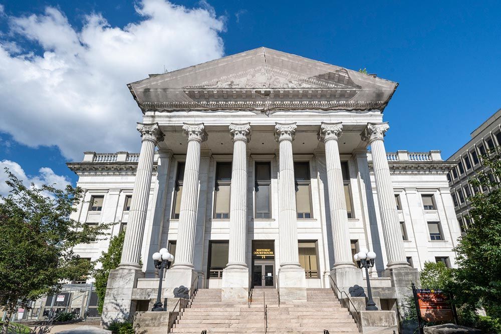 A large white building with columns and stairs in front of it.