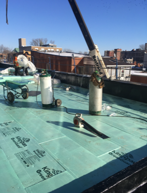 Un toit vert avec une grue en arrière-plan