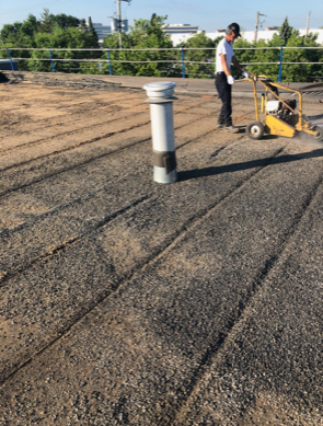 Un homme travaille sur un toit avec une machine.