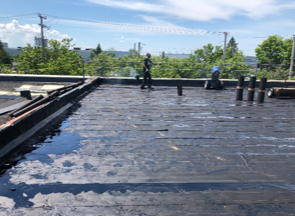 Un homme se tient debout sur le toit d'un immeuble.