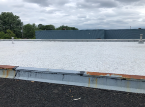 Un toit blanc avec un bâtiment bleu en arrière-plan