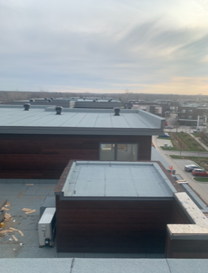 Une vue sur le toit d'un bâtiment avec beaucoup de fenêtres et un toit.