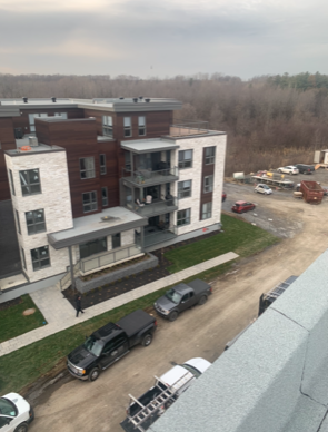 Une vue aérienne d'un bâtiment avec des voitures garées devant lui