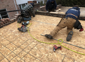 Un groupe d'hommes travaille sur un toit.