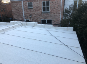 Un toit blanc avec un bâtiment en brique en arrière-plan