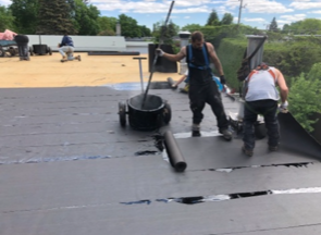 Un groupe de personnes travaille sur un toit.