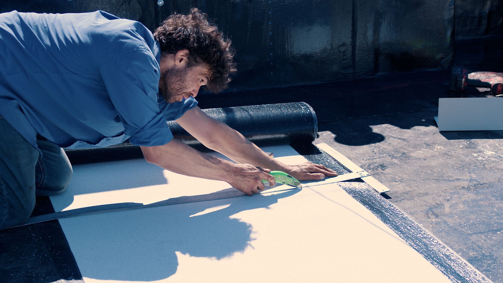 Un homme mesure un morceau de papier avec un ruban à mesurer.