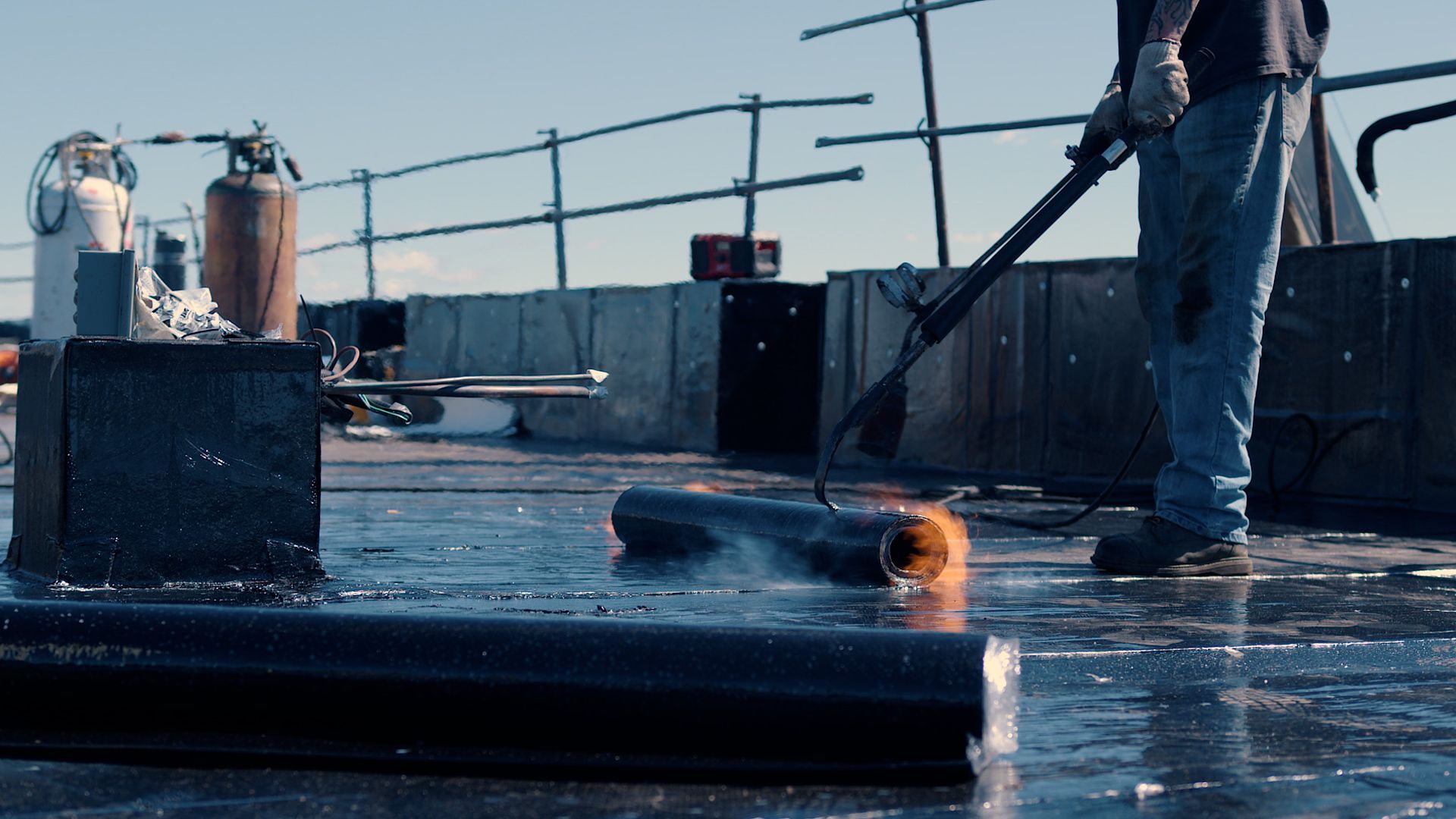 Un homme travaille sur un toit avec un aspirateur.