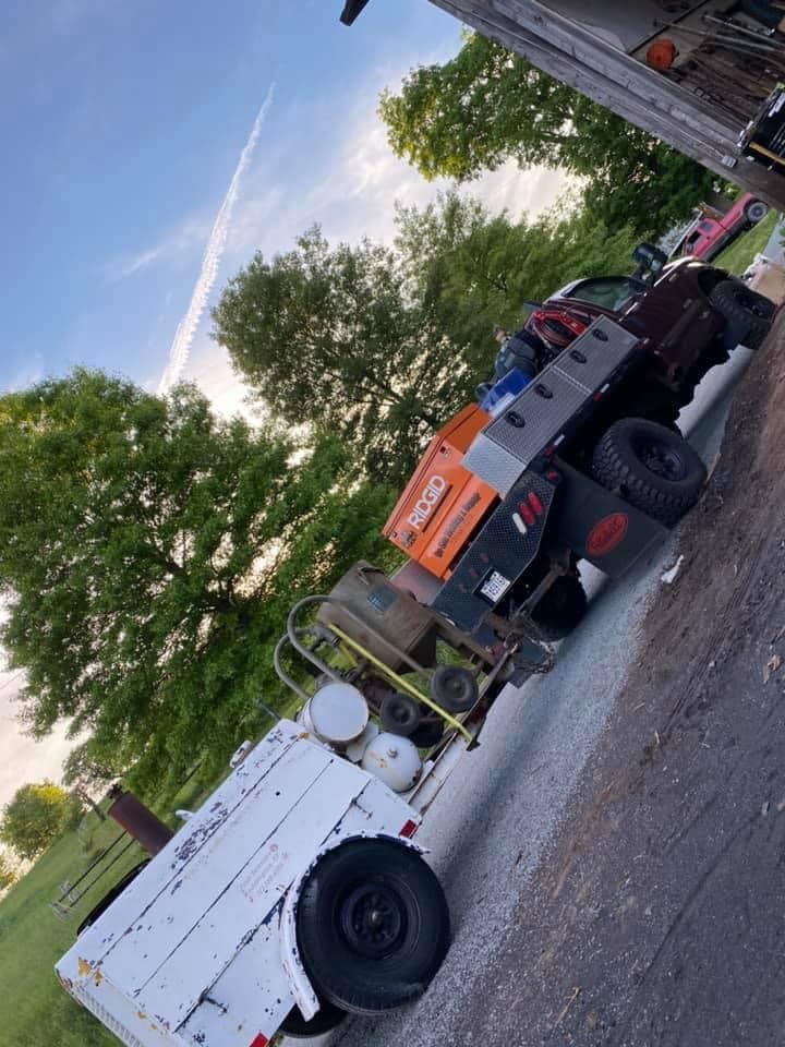 A truck and trailer loaded with tools and equipment, parked outdoors under a cloudy sky.