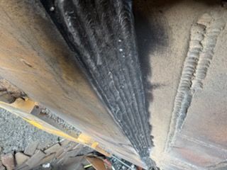 Welded metal structure showing overlapping, linear welding beads, in close-up.