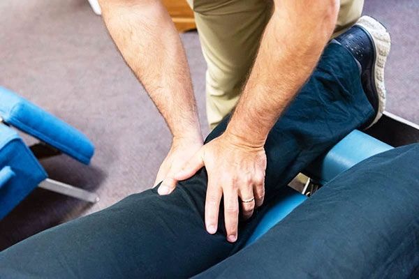 A man is giving a woman a massage on a table.