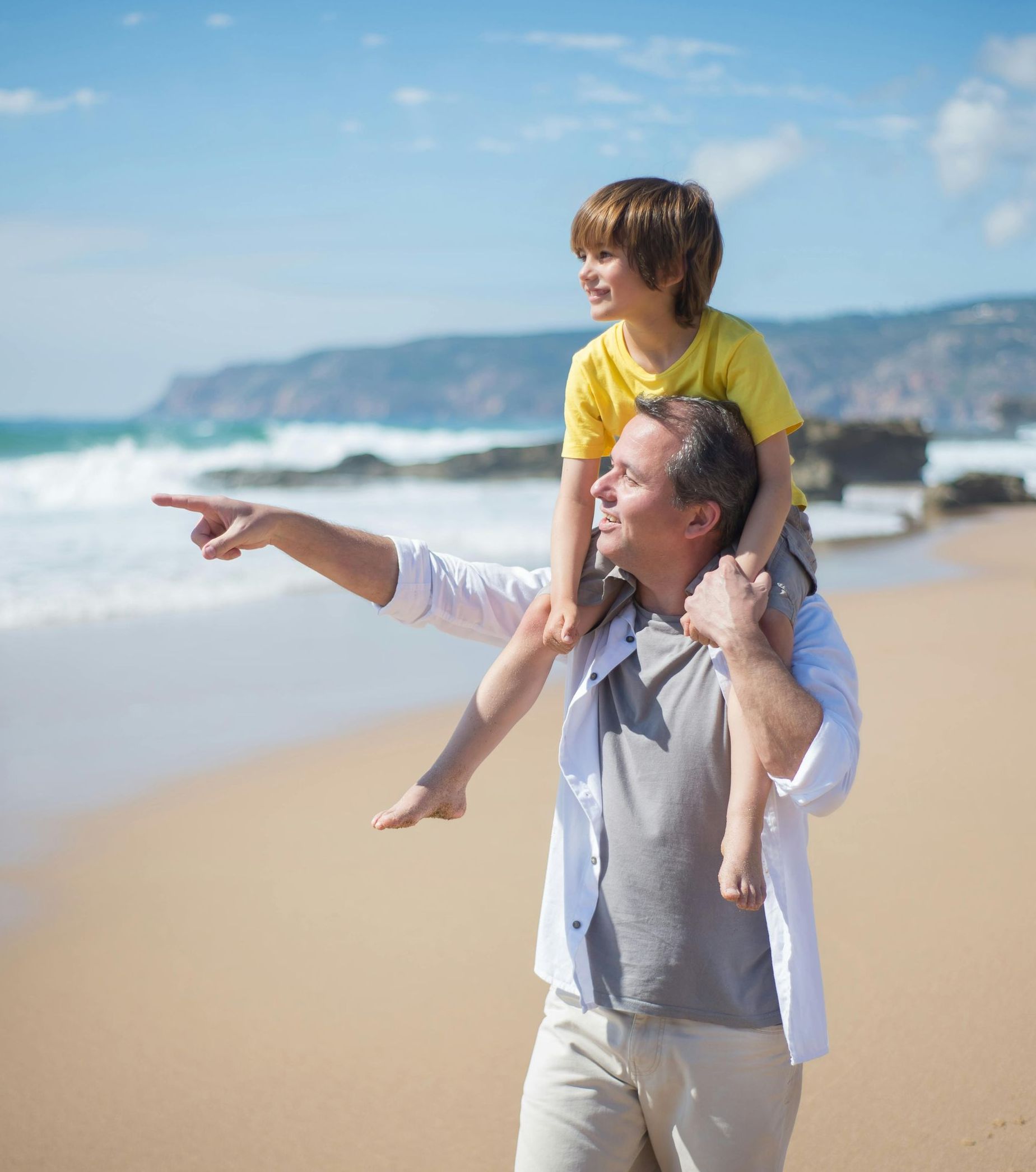 Man pointing to ocean with boy on shoulders Norfolk VA