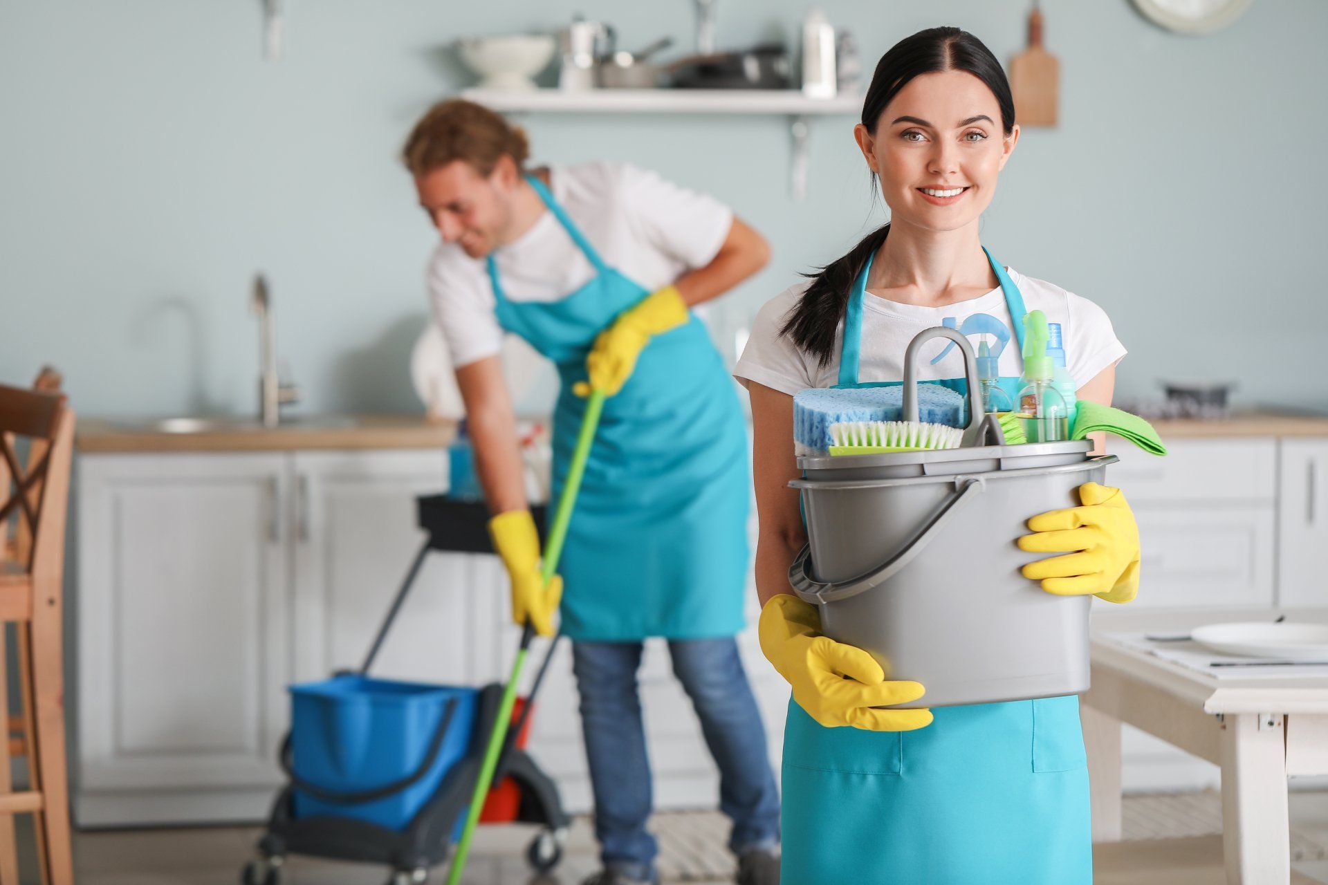 Female janitor with cleaning supplies in kitchen